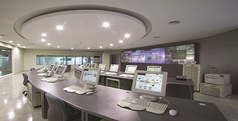 Image of room full of computors and screens on a wall